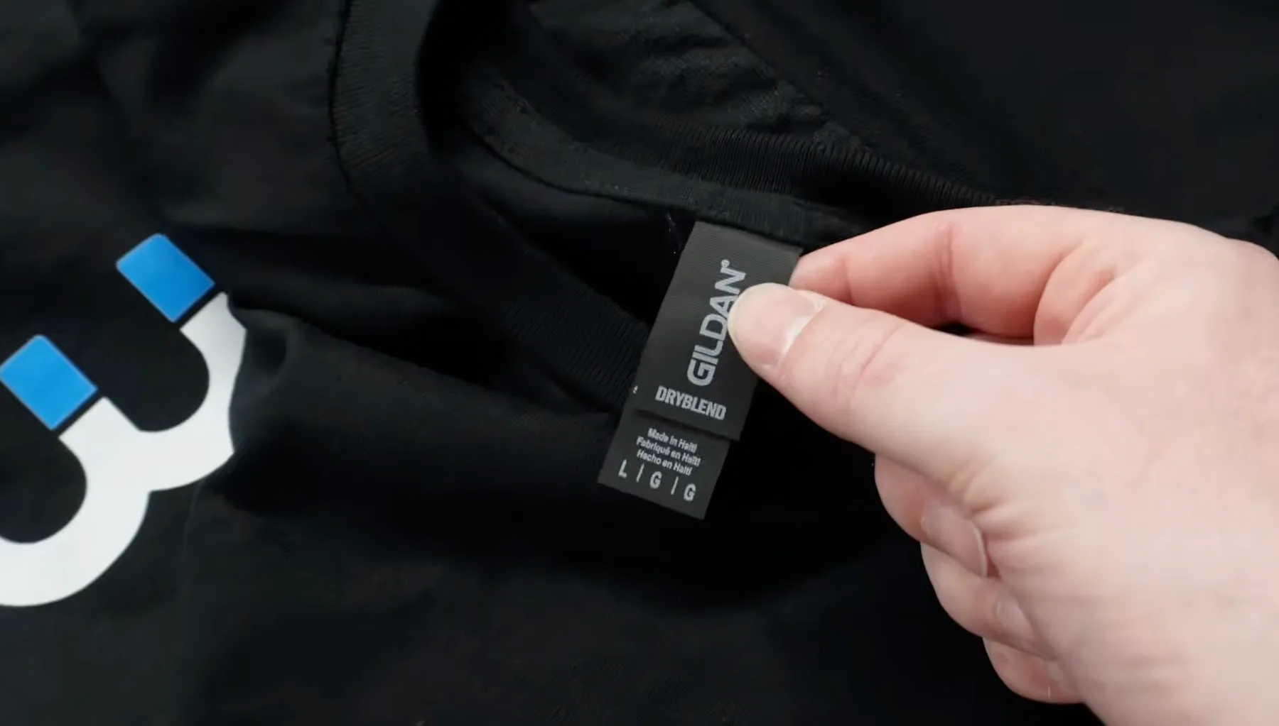 Close-up of a black Gildan DryBlend neck tag on a printed DTF shirt from an AMS production order
